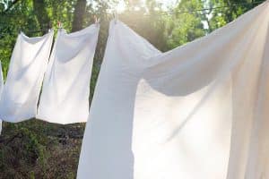 Witte lakens die te drogen hangen in de tuin