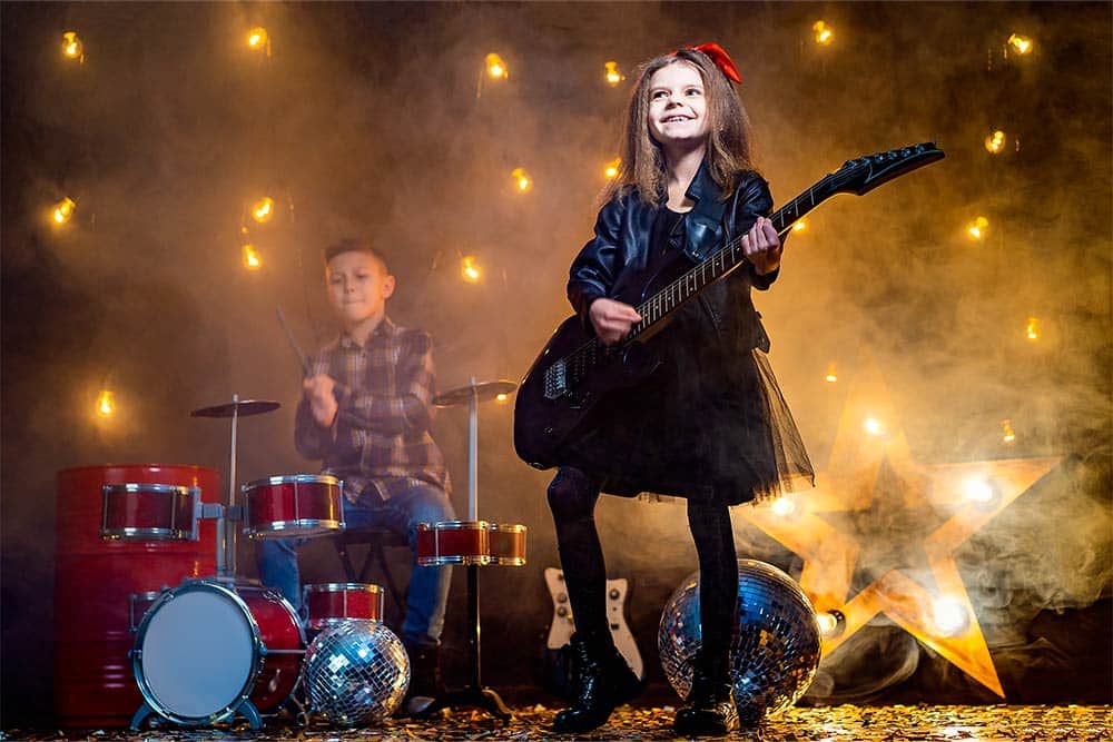 Twee kinderen in een rockband op een podium