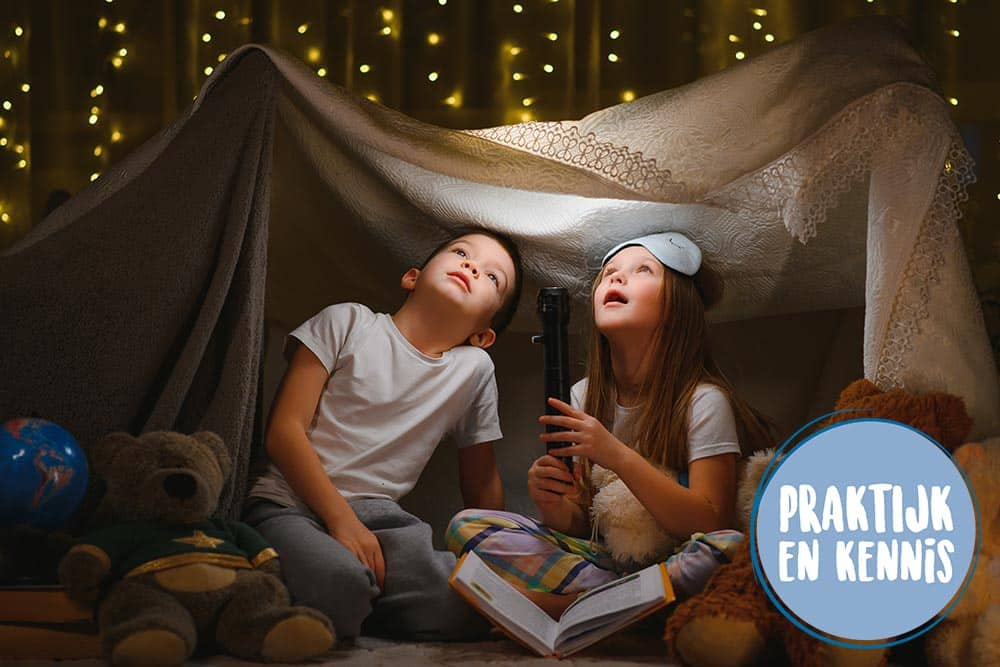 Twee kinderen spelen in het donker met een zaklamp