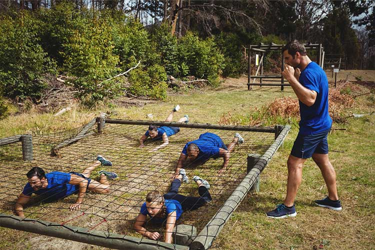 Jongeren krijgen militaire training op school en kruipen onder een net door