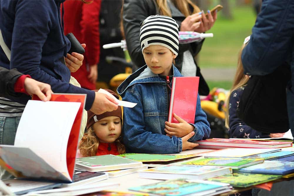 Kinderen kopen boeken op de boekenmarkt