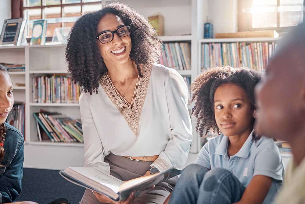 Een leerkracht leest een groepje kinderen uit de bovenbouw voor